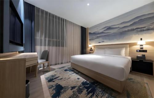 a hotel room with a bed and a television at Ausotel by Argyle Baiyun International Airport Renhe Metro Exit B in Guangzhou
