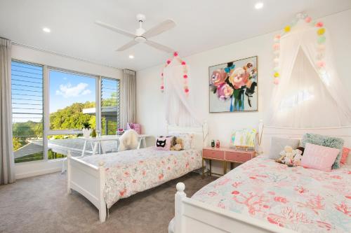Dormitorio para niñas con 2 camas y ventana en Minutes from Hastings Street, en Noosa Heads