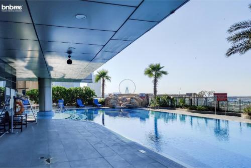 a large swimming pool in a building with palm trees at bnbmehomes - Ocean Heights in Dubai