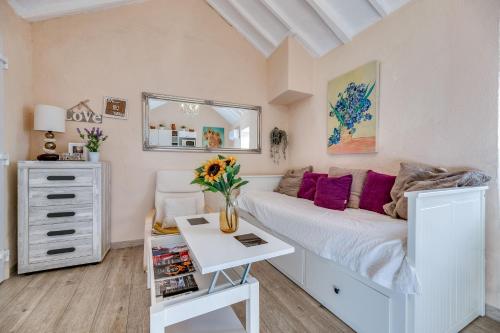 Un dormitorio con una cama y una mesa con un jarrón de flores en Casa Camelia en Ojén