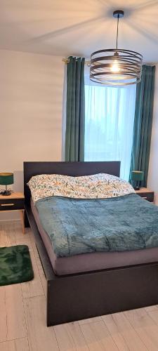 a bedroom with a bed with a large window at Apartament ROYAL in Koszalin