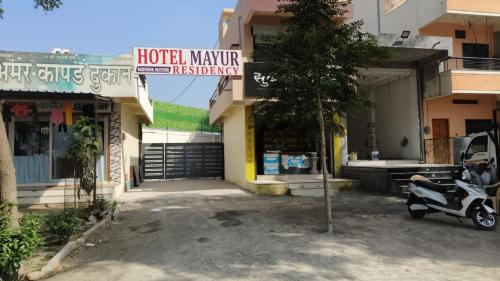 un cortile dell'hotel con una moto parcheggiata di fronte a un edificio di Hotel Mayur Residency a Ellora