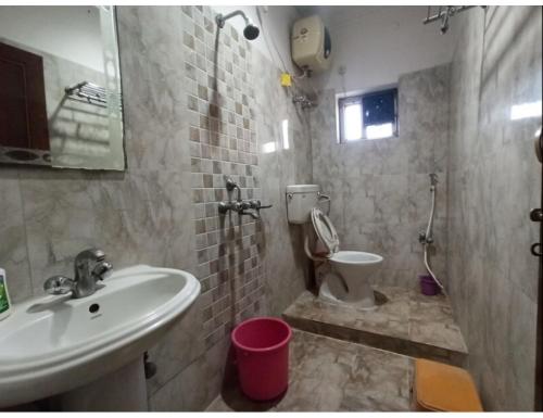 a bathroom with a sink and a toilet at Hotel Gharana, Gaya in Gaya