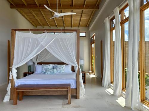 a bedroom with a bed with a canopy at Infinity Luxury Villa - Stunning Sea and Piton Views in Soufrière
