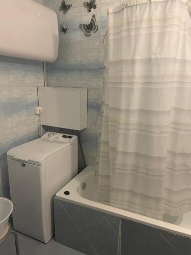 a bathroom with a toilet and a shower curtain at GERARDUS apartman in Budapest