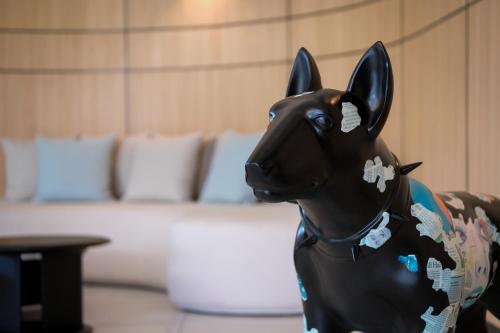 a statue of a black cow sitting in a room at Sole Mio Boutique Hotel and Wellness - Adults Only in Bang Tao Beach