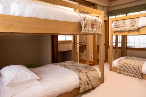 two bunk beds in a room with at Kihachikan North Nozawa Onsen in Nozawa Onsen