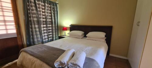 - une chambre avec un lit et des serviettes dans l'établissement Hexberg Cottage, à Wellington