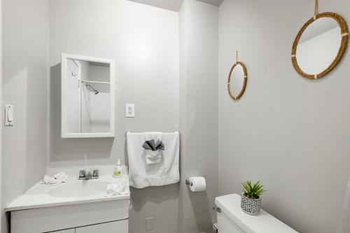 a white bathroom with a sink and a mirror at Stylish 1br Unit Bella Vista By Center City in Philadelphia
