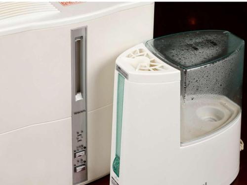 a trash can in the corner of a white refrigerator at Zentsuji Grand Hotel in Zentsuji