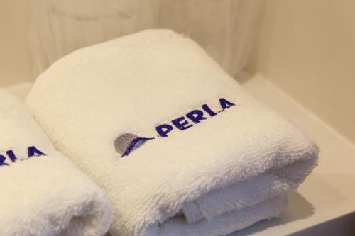 a pile of towels with the word perilla on them at Perla Luxury in Ulcinj