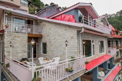 a building with white balconies and tables and chairs at Saanjh - The Musical Sunset in Shimla