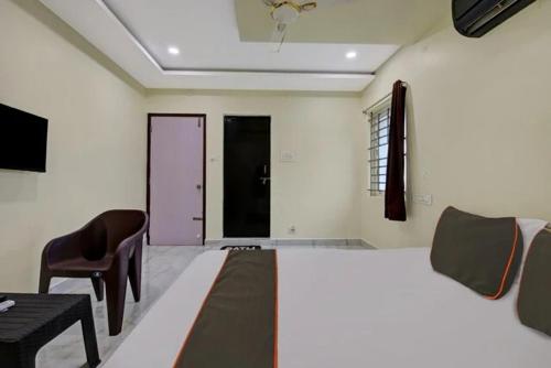 a bedroom with a bed and a table and a chair at Ns Beach Resort in Bhīmunipatnam