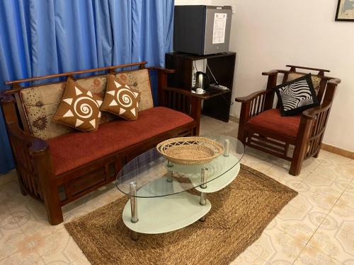a living room with two chairs and a glass table at Kenno's Korner in Weligama