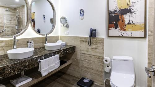 a bathroom with two sinks and a mirror at Holiday Inn Santo Domingo by IHG in Santo Domingo