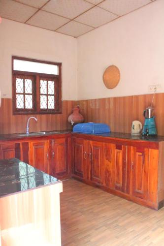 a kitchen with wooden cabinets and a counter top at Mango House in Talalla