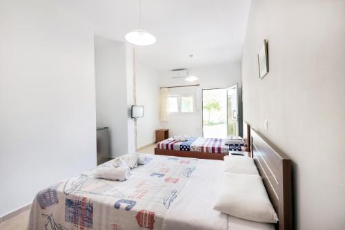 Habitación blanca con 2 camas y espejo. en Istira, en Possidi