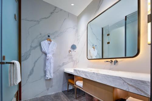 bagno con lavandino e specchio di Grand Mercure Chengdu East a Chengdu