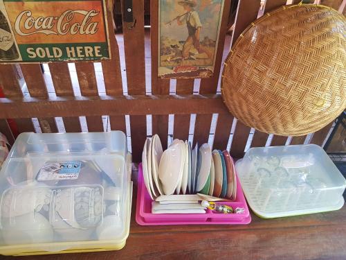 a plastic container with utensils in it next to a basket at Kedthawa Homestay เฮือนเก็ดถะหวา in Ban Cho Lae