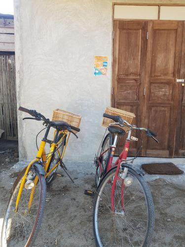two bikes parked next to a building with a door at Kedthawa Homestay เฮือนเก็ดถะหวา in Ban Cho Lae