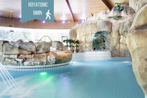 une grande piscine dans un parc aquatique dans l'établissement Le Royat Palace - Wifi - Confort, à Royat
