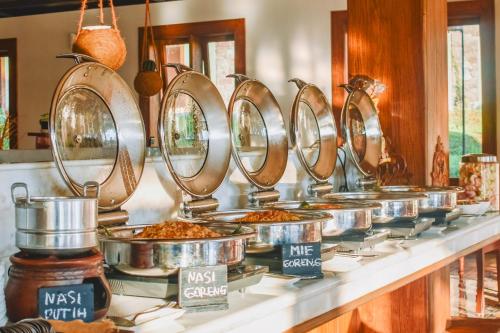 a row of pans of food on a counter at Shanaya Resort Malang in Malang