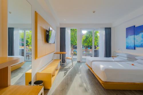 a bedroom with a large bed and a tv at Kuta Beach Club Hotel in Kuta