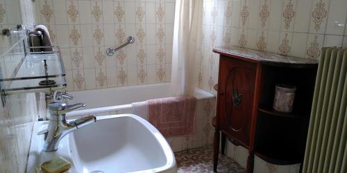 ein Badezimmer mit einer Badewanne und einem Waschbecken in der Unterkunft Villa Lulu in Mérignac