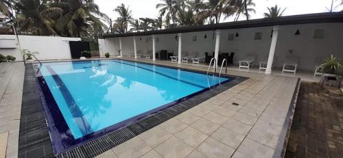 a large swimming pool next to a building at Ocean Villa in Panadura