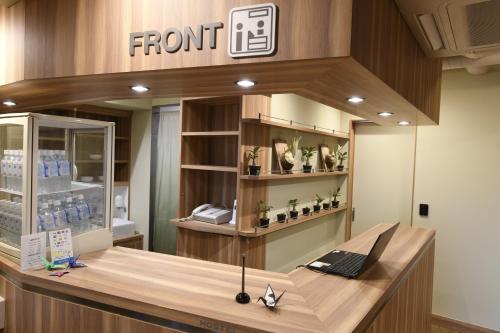 a front desk in a store with a sign on the wall at A16 HOSTEL TOKYO in Tokyo