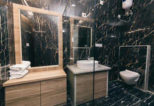 a black bathroom with a sink and a toilet at Serenity Hill Resort & Spa in Udaipur