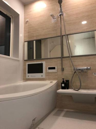 a bathroom with a tub and a shower in it at Tanuki Shinjuku in Tokyo