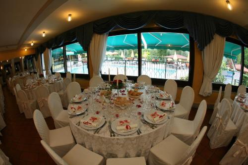 a dining room with a table with white chairs at Hotel La Ruota in Pianfei