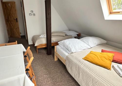 Habitación pequeña con 2 camas y espejo. en Lawendowa Wola - noclegi w Izerach en Giebułtów