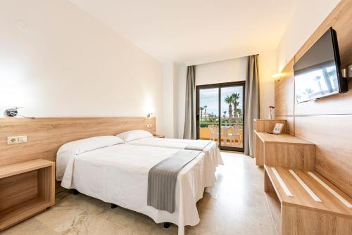 A bed or beds in a room at Hotel Toboso Almuñécar