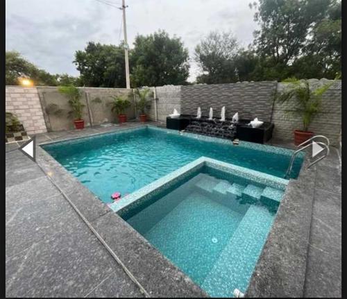 uma piscina com água azul num quintal em Runaway villa em Hyderabad