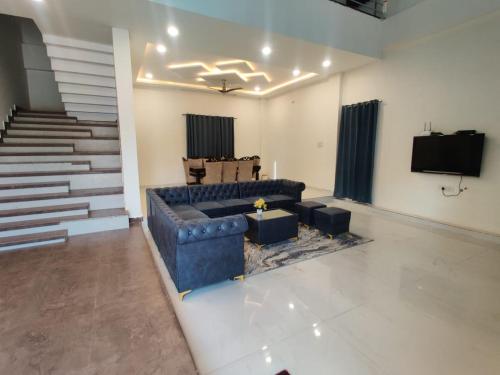 uma sala de estar com um sofá azul e uma televisão em Runaway villa em Hyderabad