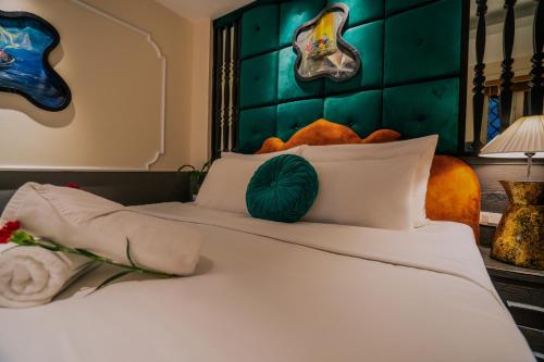 a bedroom with a white bed with a green headboard at Hanoi Center Silk Classic Hotel & Travel in Hanoi