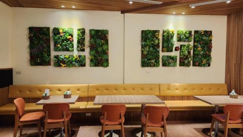 ein Esszimmer mit Tischen, Stühlen und Gemälden an der Wand in der Unterkunft 車站100m民宿丨電梯附停車場 in Hualien