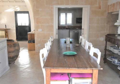uma sala de jantar com uma mesa de madeira e cadeiras brancas em ALBALAT em Alaior