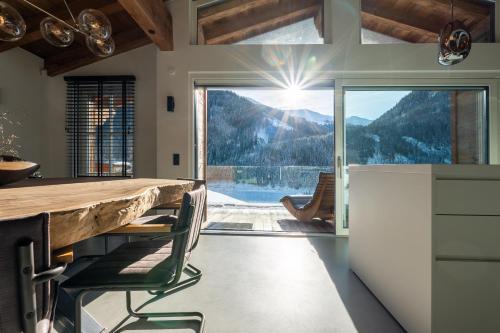 uma cozinha com uma mesa e vista para uma montanha em Lavender Hill - Summer holiday & ski chalet/villa em Saalbach-Hinterglemm