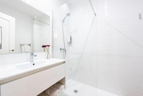 a white bathroom with a sink and a shower at Hotel Toboso Almuñécar in Almuñécar