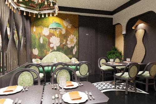 a dining room with tables and chairs and a floral wall at Hanoi Center Silk Classic Hotel & Travel in Hanoi