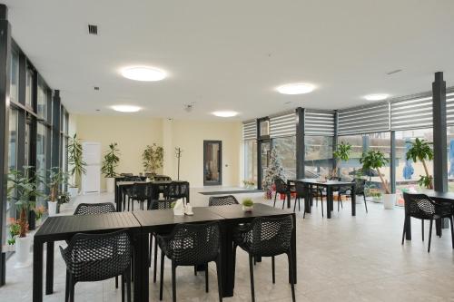 阿拉木圖的住宿－Saraishyq Hotel，用餐室设有桌椅和窗户。