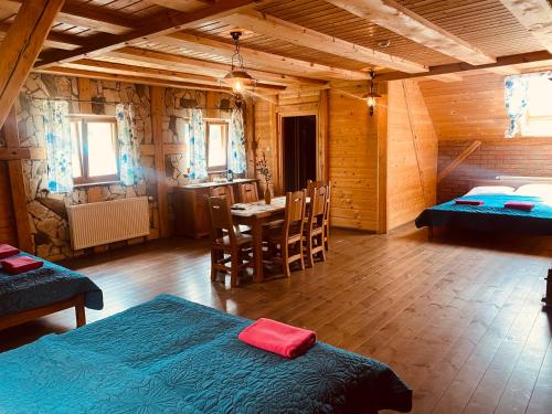 a room with two beds and a table and a kitchen at Agroturystyka Agro-Podkówka in Marciszów