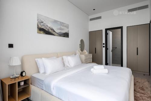 1 dormitorio blanco con 1 cama blanca grande con almohadas blancas en 2BR-D4-15NS Chic Business Bay Apt en Dubái