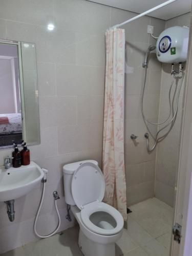 La salle de bains est pourvue d'une douche, de toilettes et d'un lavabo. dans l'établissement apartemen podomoro city medan, à Medan