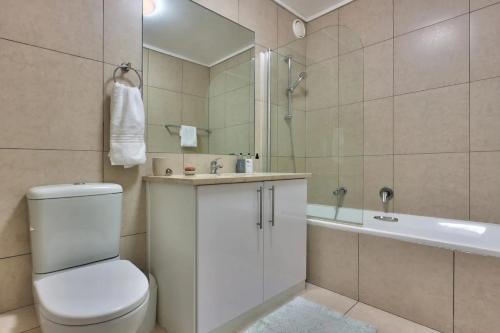y baño con aseo, lavabo y bañera. en Stylish sea-facing apartment with underground parking, en Ciudad del Cabo