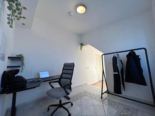 a office with a desk and a chair and a laptop at Parkplätze, Einzelbetten, 2 Balkone, fast Wi-Fi 100 Mbit, Homeoffice, Aufzug, lichtdurchflutet, Panoramablick in Erlensee