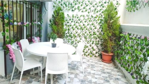 a patio with a white table and chairs and plants at Alpacino Apart Hotel in Istanbul